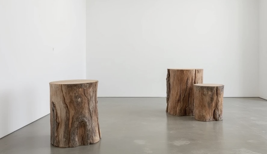 Ditch expensive manufactured plinths for raw log pedestals that offer a stunning, organic contrast to modern artwork.