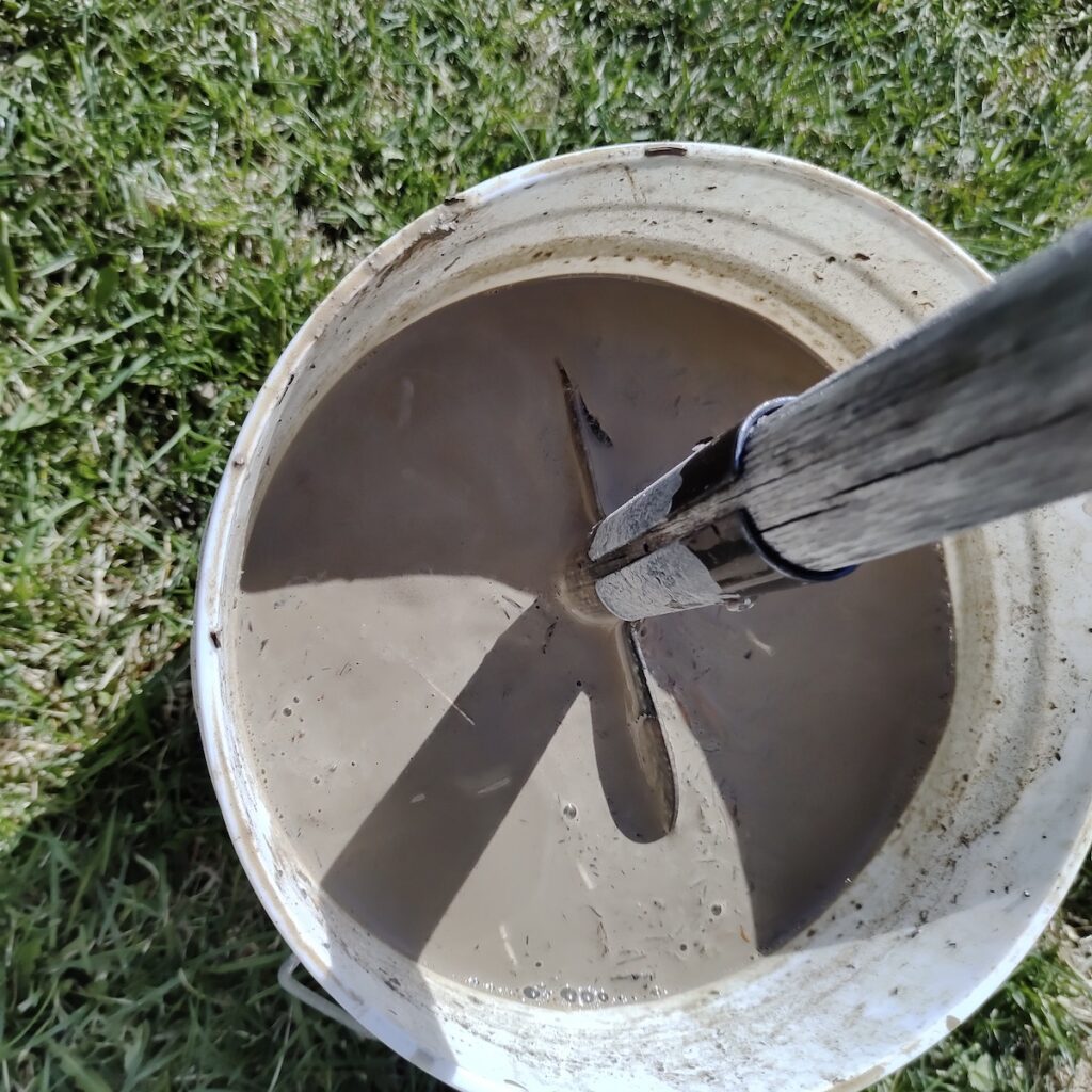 A look inside our main processing bucket, where raw clay dug from Melgund is submerged in water for the slaking process. By breaking down the dense chunks into a uniform, creamy slurry, we can easily separate the pure clay from background grit. This smooth liquid is now perfectly primed for the first round of coarse straining.