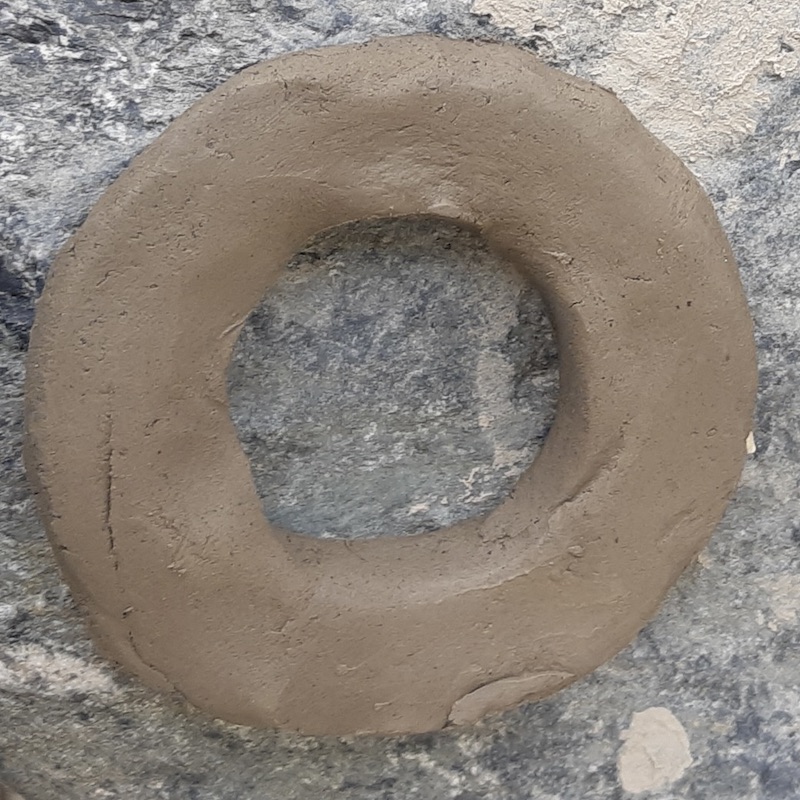 Before: Testing our processed wild clay during today's summer arts session. This wet hoop went straight from the filter screen onto a granite boulder to bake in the July sun—completely un-wedged and with no smoothed seams to see how it handles maximum drying stress.