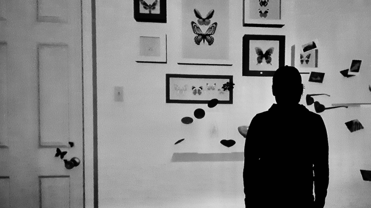 A figure halts the stream of image—momentarily. Not to block it, but to hold it, to be shaped by it. Projection meets person, and neither stays the same. Shadows don’t erase light; they reveal where it lands.