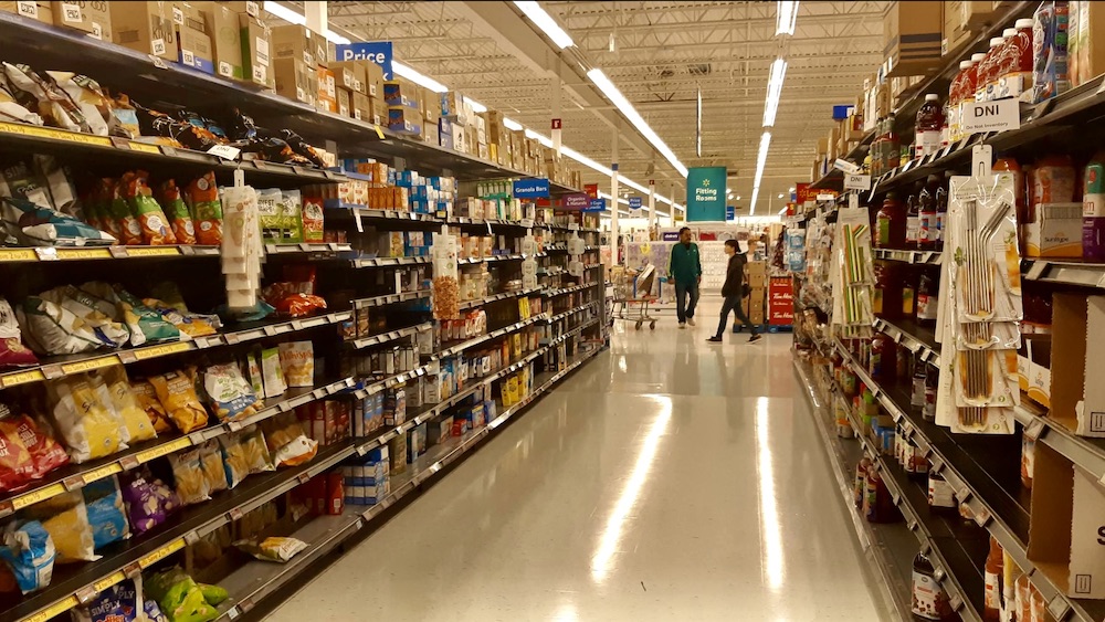 Aisle lights flicker like low-budget auroras. A cart drifts alone, existential, beneath a sky of suspended rollback signs. Somewhere between frozen peas and bulk ramen, time folds. The artist doesn't seek inspiration—they forage. The absurdity of price becomes performance. Meaning hides in markdowns. Surveillance watches, but never truly sees.