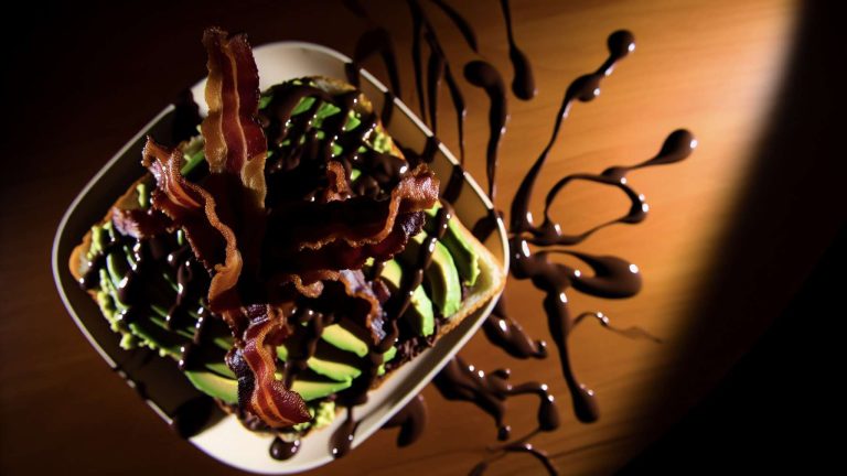 This week’s AI Food Art Friday brings an unexpected twist to the classic avocado toast, combining rich dark chocolate with crispy bacon and creamy avocado. The fusion of savory and sweet creates an intriguing contrast, both in flavor and in photography potential.