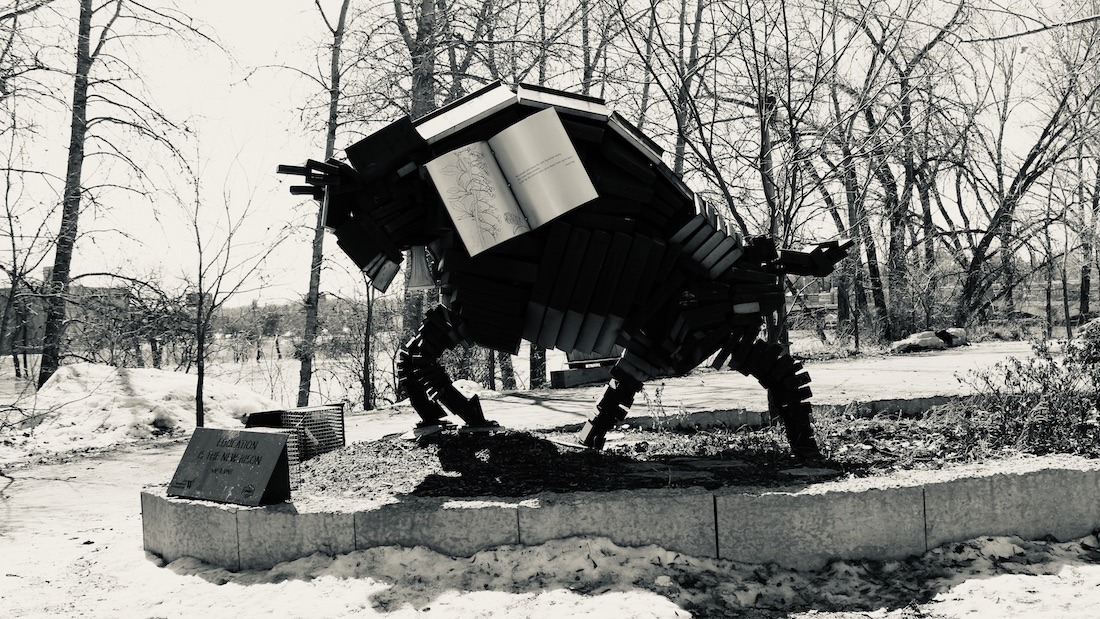 Among bare branches and snow-laced silence, the book-buffalo waits—pages frozen in time, wisdom stacked into muscle and memory. It is not sculpture, but spellwork. It holds what we forgot we carried: story, survival, and the soft hoofbeats of future paths.