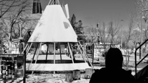 In Winnipeg’s playgrounds, metal tipis rise like echoes of old songs, catching sky in their spines. These are not structures but spells—frames for imagined fires and stories unspoken. Here, laughter roots in the dust, spiraling upward. Memory plays barefoot, circling the sacred geometry where past and future quietly braid. Photo: Jamie Bell