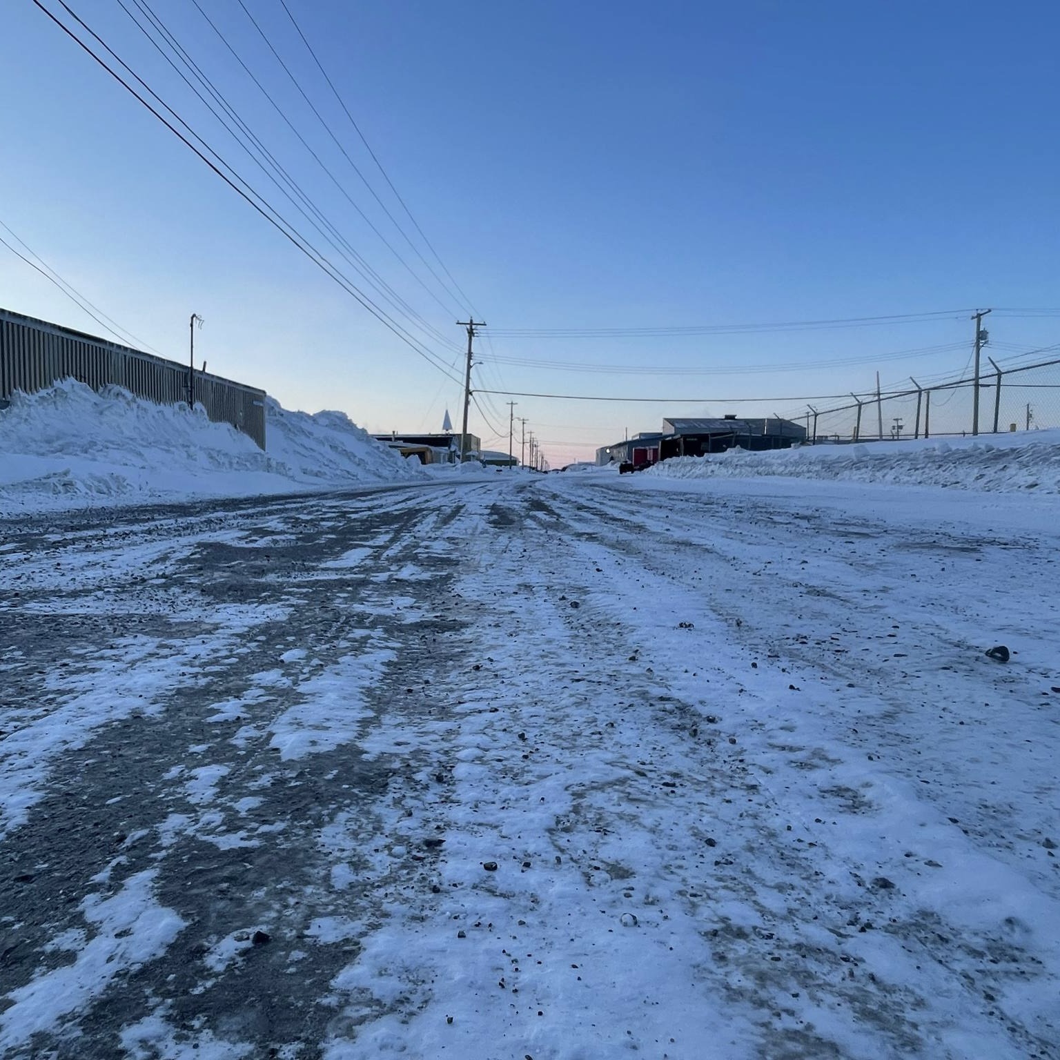 Snow and street. Our path, right here in town. Where does it lead? What will it look like tomorrow? The light on the snow, it tells a story. A story of change, even here, where we live. This isn't just a street; it's our future, covered in white, waiting to be seen.