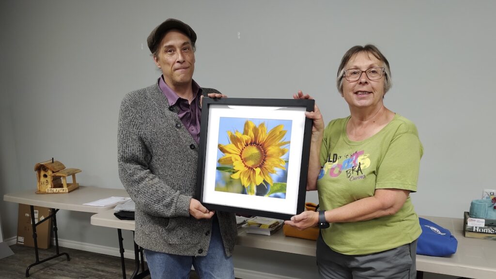 Jamie Bell from The Arts Incubator presents a signed print to Michelle Robinson from the Local Services Board of Melgund for their upcoming Silent Auction to be held during Canada Day activities.