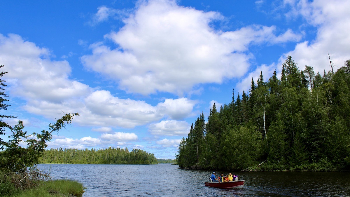 Surrounded by boreal forest, boaters on Melgund Lake experience the quiet beauty of protected waters and rich fishing traditions.