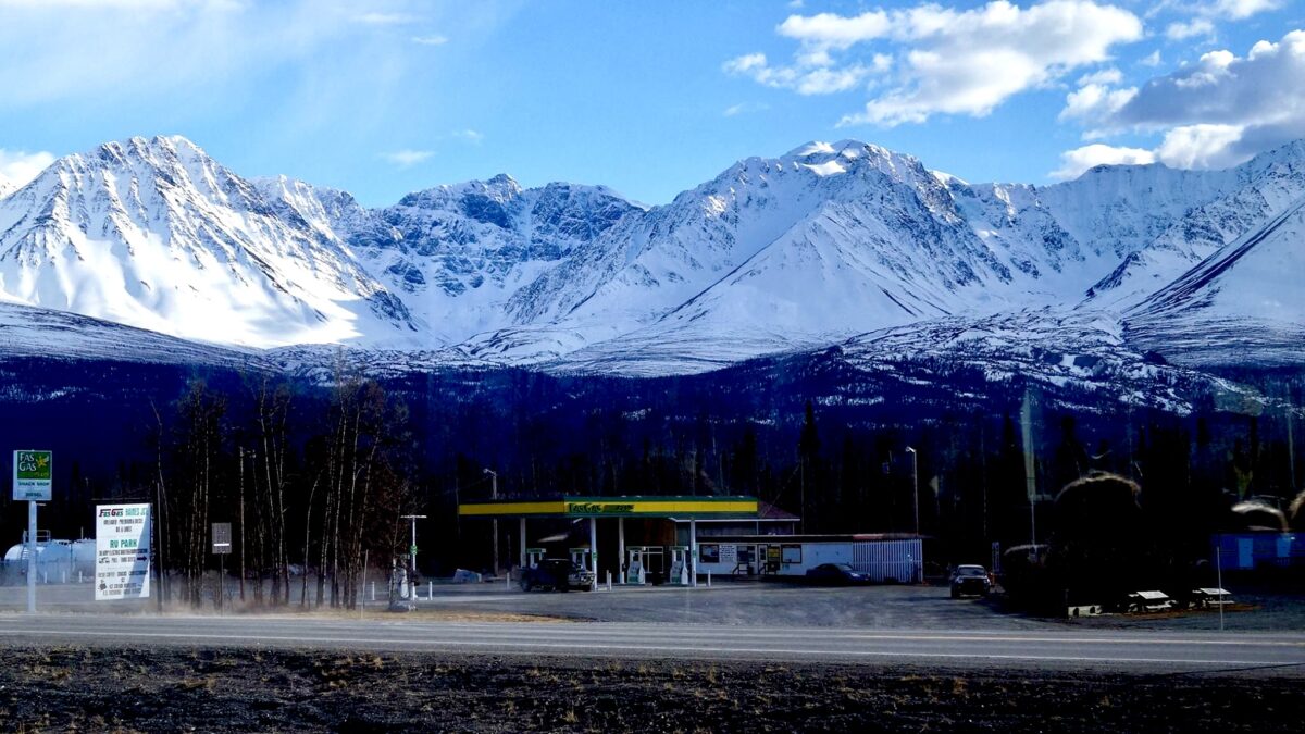 The Fas Gas station in Haines Junction, Yukon, looking spectacular against the towering, snow-capped St. Elias Mountains. This stunning view was captured while walking along the Alaska Highway.