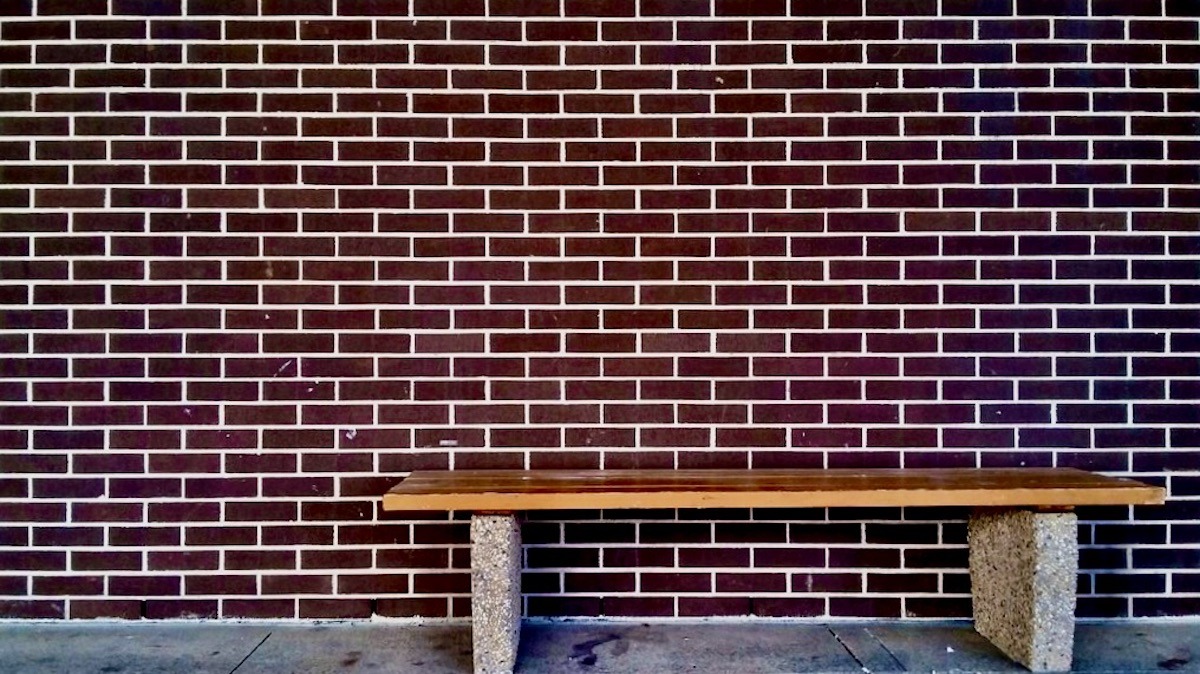 Against a stark brick backdrop, this unassuming Windsor bench serves as an open-air boardroom where artists gather to dissect concepts, share stories, and connect under the open Canadian sky.