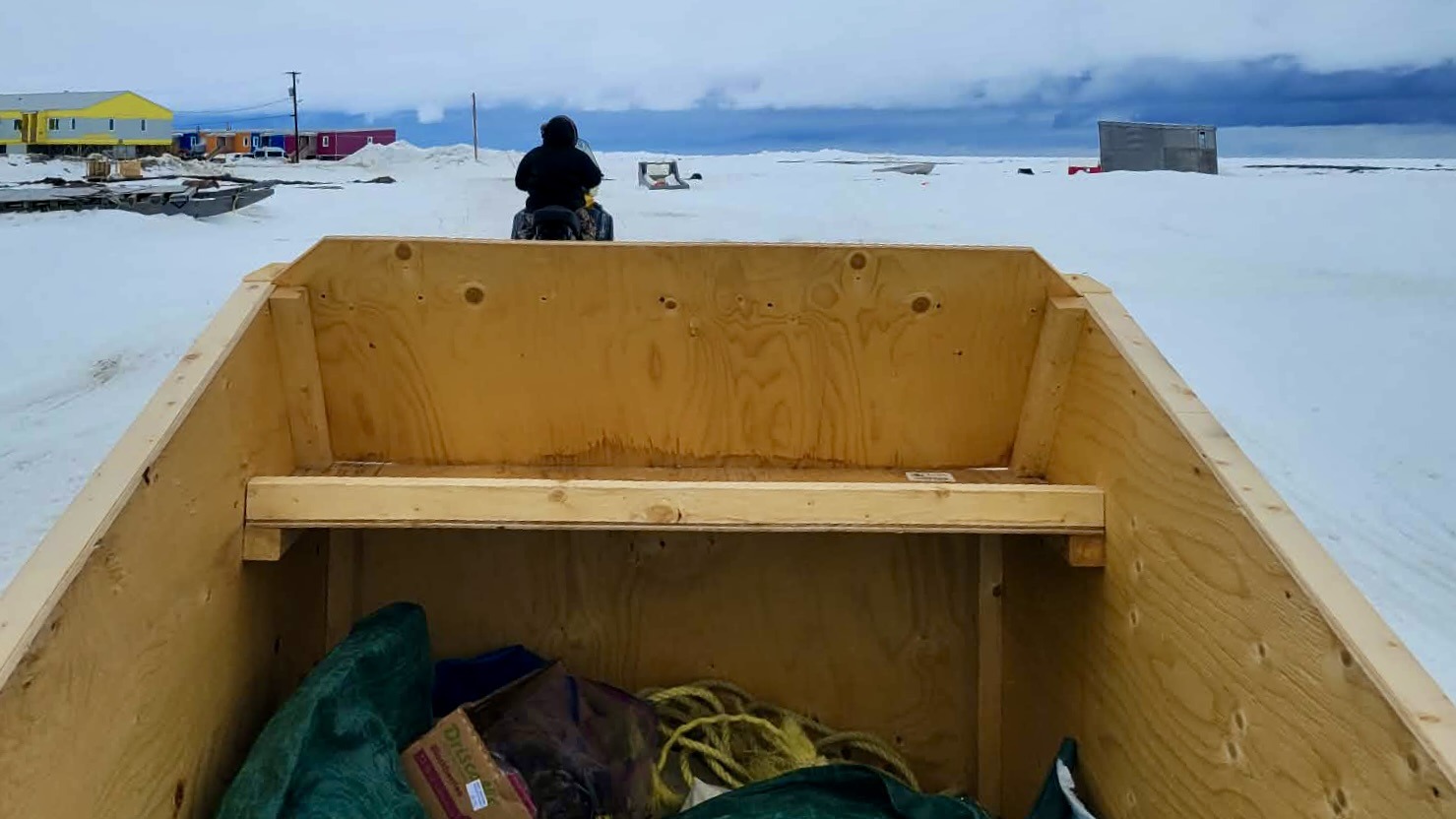 Towed along in a sturdy wooden qamutik, you feel the crisp, biting air hitting your face.