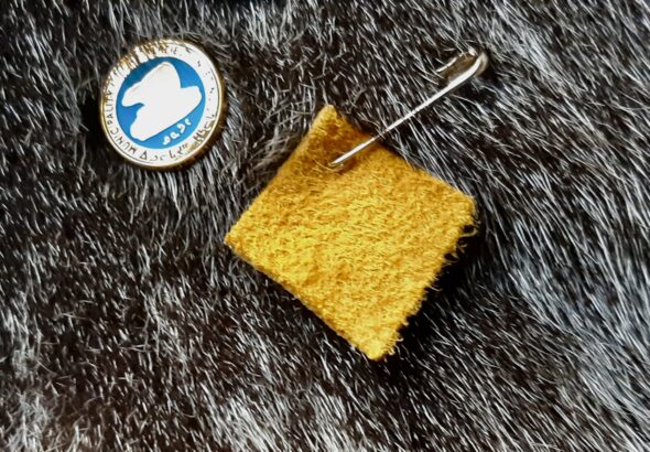 A small square of moose hide pinned close to the heart, symbolizing a personal commitment to stand against violence and support safer, more respectful communities.