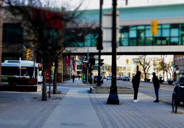 The tilt shift lens brings focus to the heart of the sidewalk, blurring the heavy traffic and overhead skywalks to emphasize the people who make Winnipeg feel truly, deeply alive.