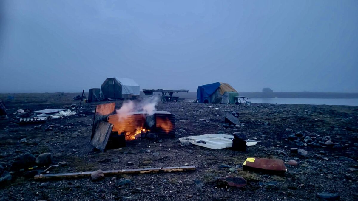 Caribou cooks over an open fire at our family camp on the western shores of Hudson Bay near Arviat, Nunavut. The camp remains an important gathering place where traditional knowledge, family stories, and Inuit cultural practices are shared across generations.