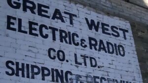 The weathered facade of this old radio sign shows the cracked paint and enduring hand-lettered signage from Winnipeg's mid-century commercial heyday.