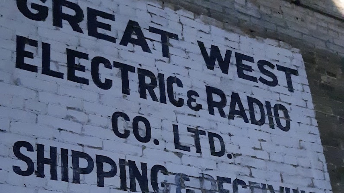 The weathered facade of this old radio sign shows the cracked paint and enduring hand-lettered signage from Winnipeg's mid-century commercial heyday.