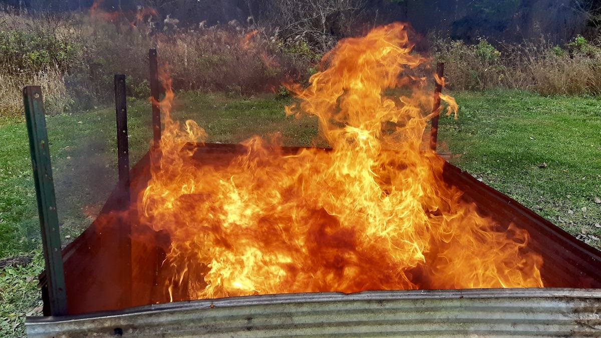 Now that's a fire! After waiting all summer for the right conditions, the Art Borups Corners Society finally has its first pit firing underway. The flames are roaring, the wood is burning hot, and our partners' handmade local clay pieces are getting their first taste of the fire.